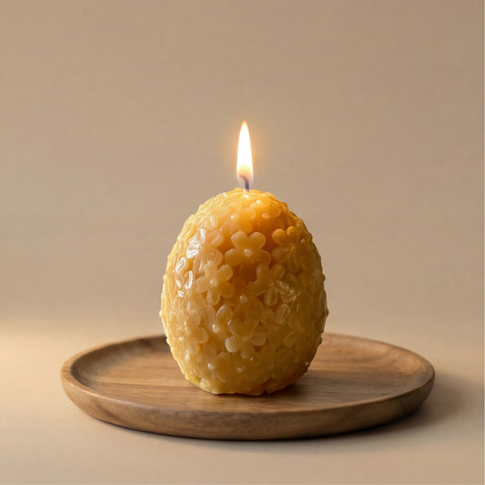 Natūrali rankų darbo bičių vaško žvakė kiaušinio formos su gėlių raštais.